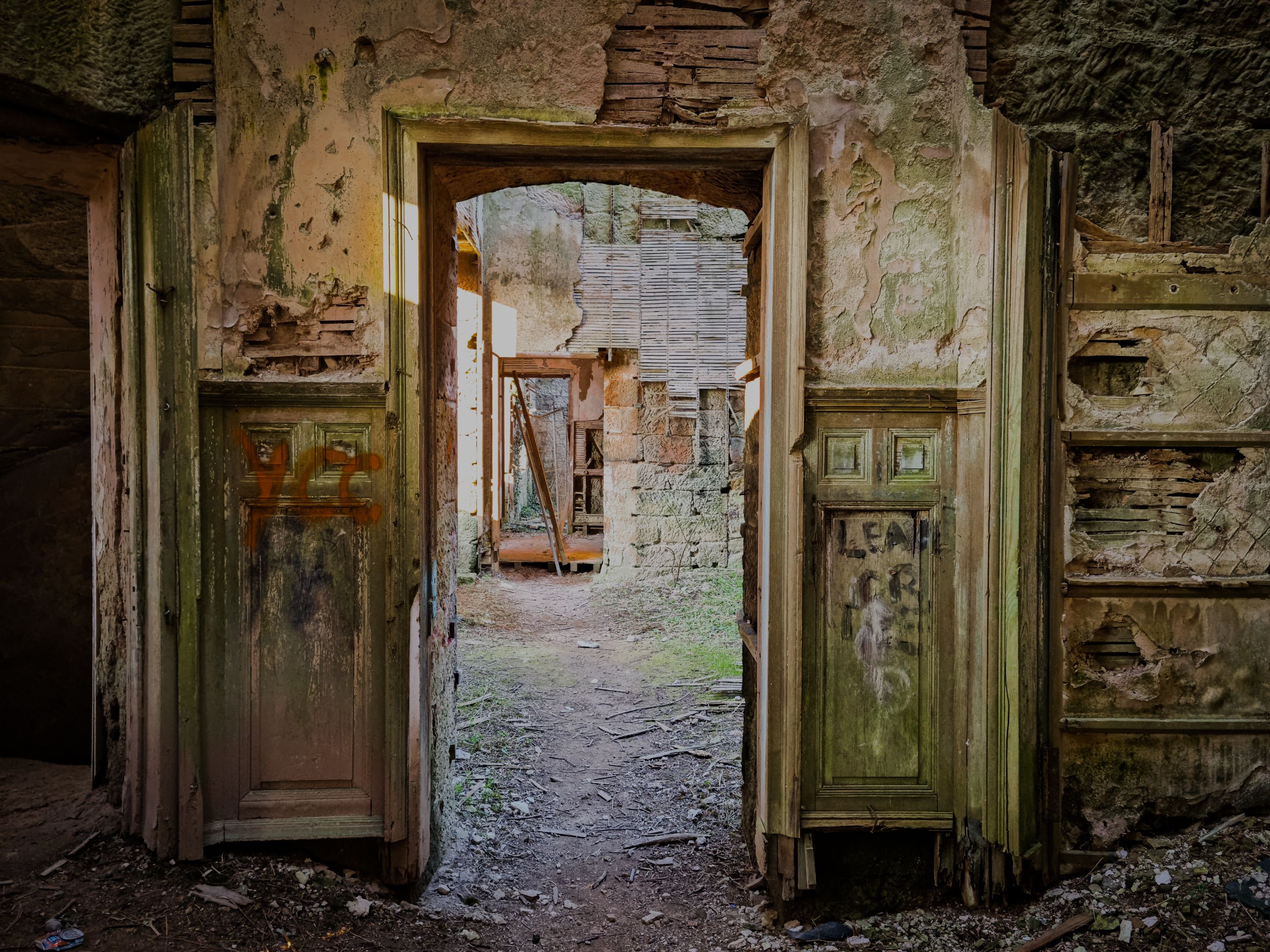 Weathered doorway opening onto an overgrown garden