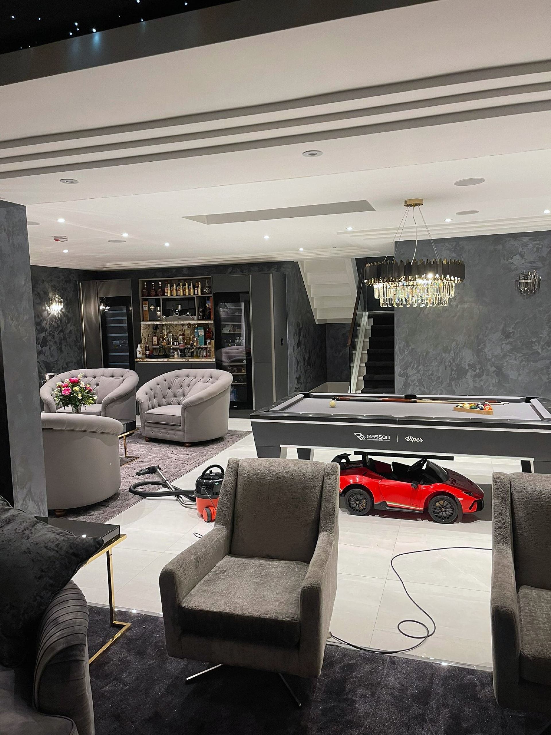 Basement lounge with a bar, sofas and a pool table