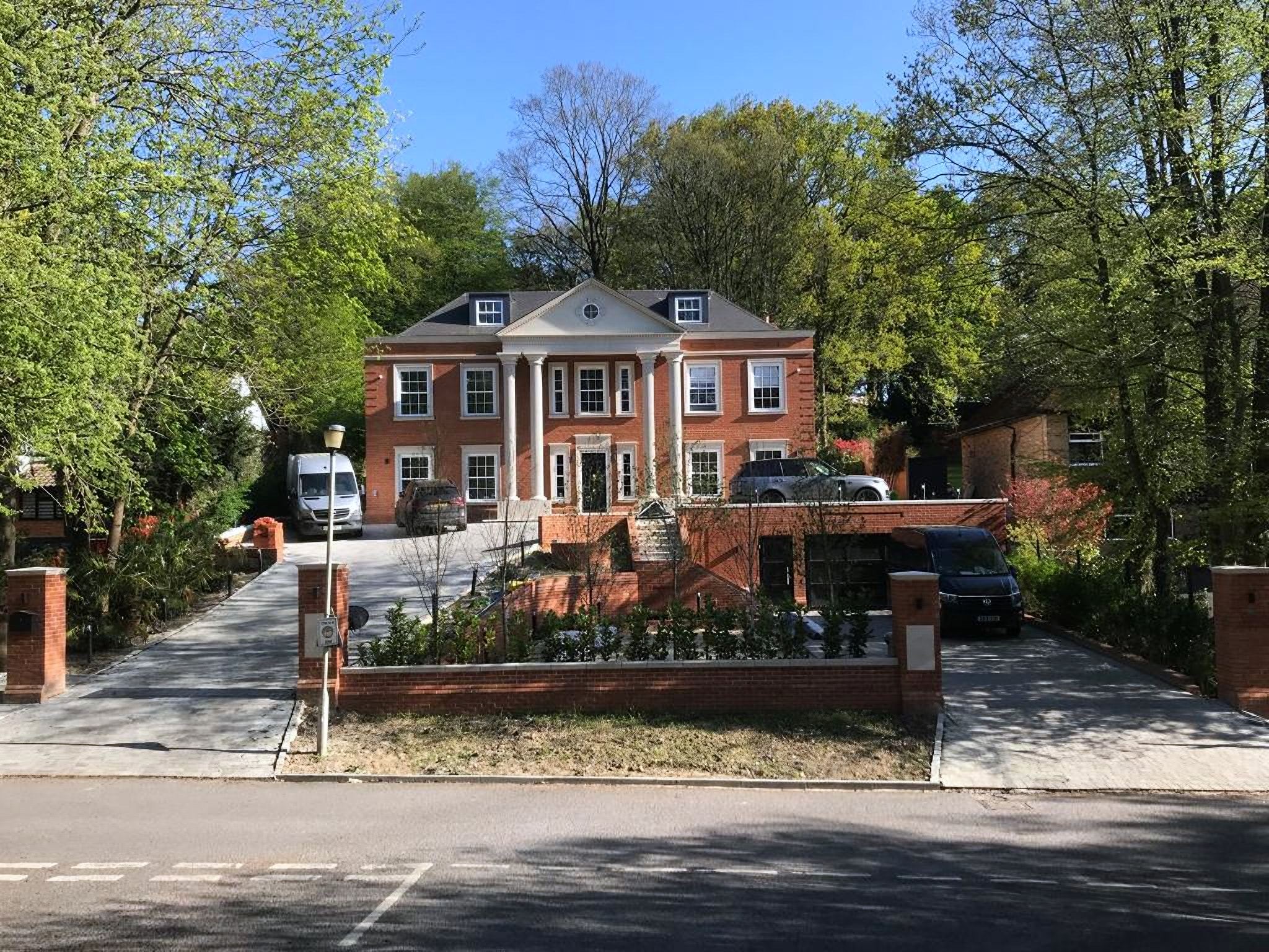 Camp Road, a red-brick SEJ home with a columned portico, seen from the road