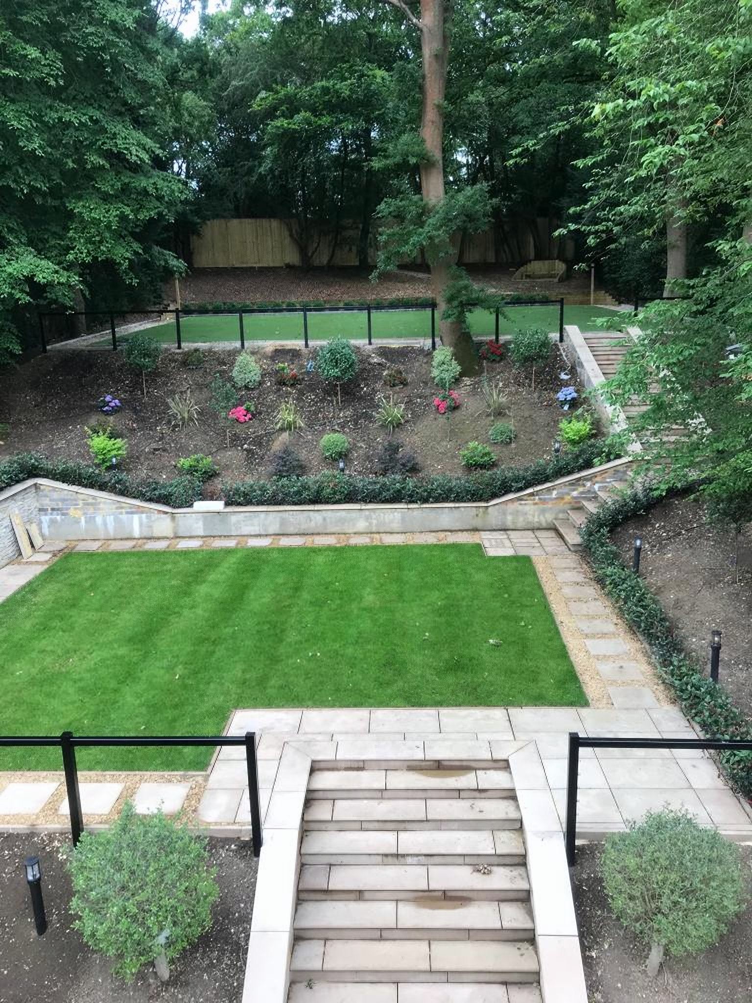 Terraced garden with a striped lawn and stone steps