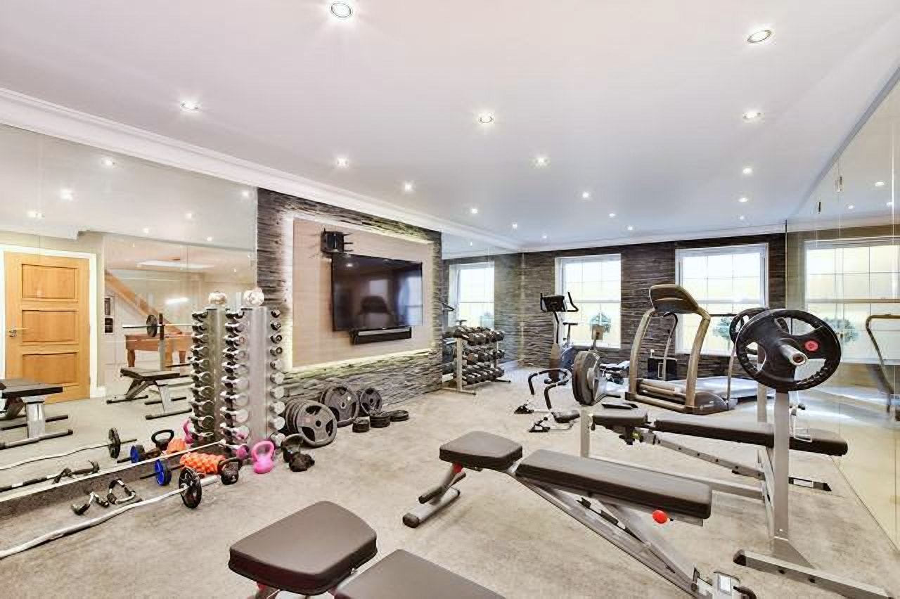 Home gym with a weights rack and mirrored wall