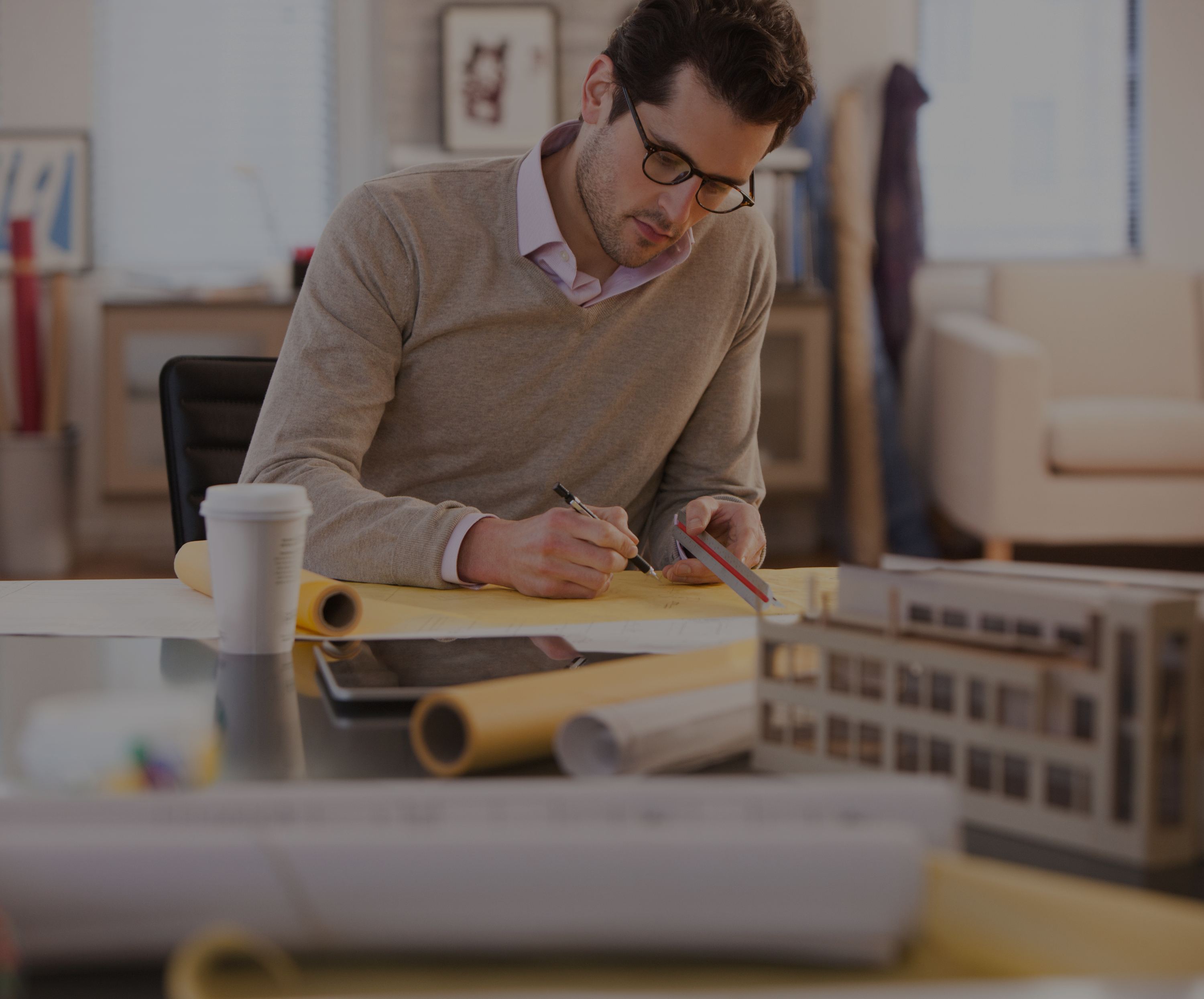 Architect working on drawings at a desk